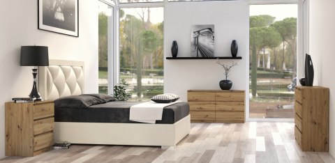 Komoda 140 cm dąb artisan KOM-906-ART w aranżacji sypialni – widok przedni mebla z kwiatem na blacie.