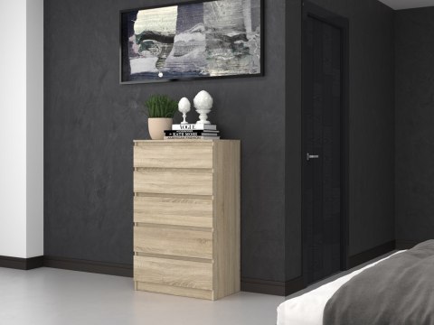 Stylowe wnętrze w stylu z funkcjonalną komodą dąb sonoma KOM-903-SON w półprofilu.