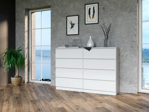Stylowe wnętrze salonu z funkcjonalną białą komodą KOM-908-BIEL-MAT w półprofilu.